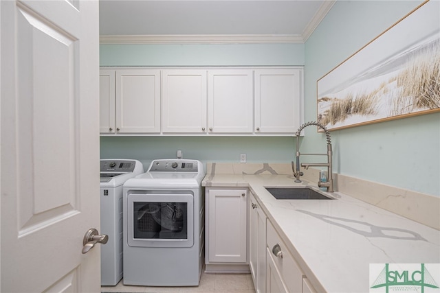 clothes washing area with sink, cabinets, ornamental molding, light tile patterned floors, and washing machine and dryer