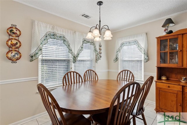 tiled dining area with an inviting chandelier and a textured ceiling