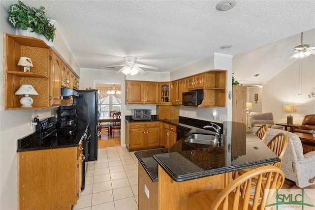 kitchen with sink, light tile patterned floors, black appliances, ceiling fan with notable chandelier, and kitchen peninsula