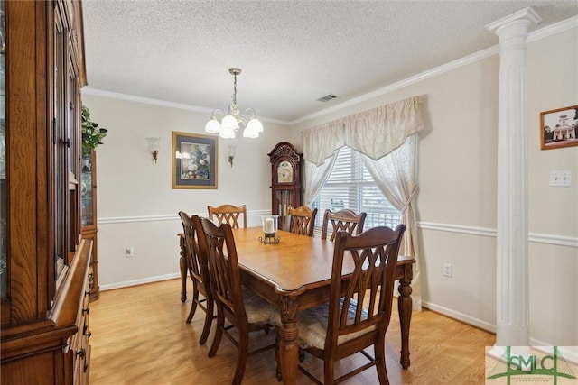 dining space featuring crown molding, a notable chandelier, a textured ceiling, and light hardwood / wood-style flooring