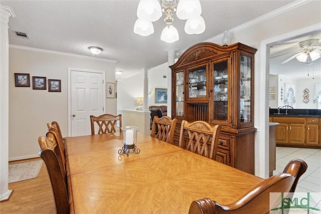 dining room featuring crown molding, decorative columns, and a textured ceiling