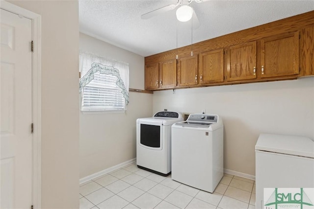 washroom with light tile patterned floors, ceiling fan, cabinets, washer and dryer, and a textured ceiling