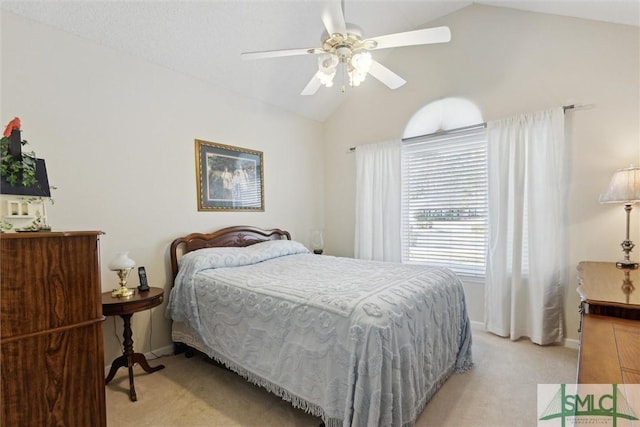 bedroom with vaulted ceiling, light colored carpet, and ceiling fan