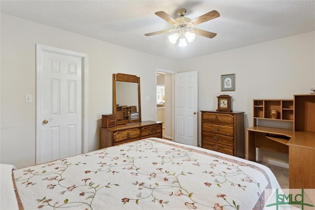 bedroom with ceiling fan and a textured ceiling