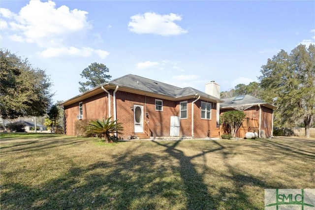 rear view of house featuring a lawn