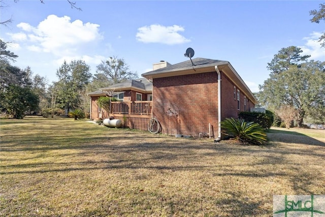 rear view of house with a wooden deck and a lawn