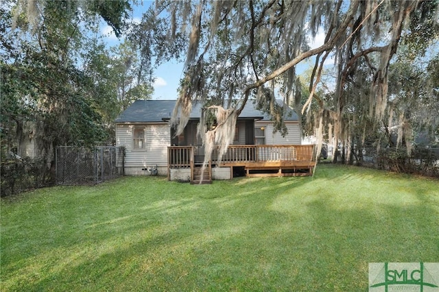 rear view of property featuring a wooden deck and a lawn