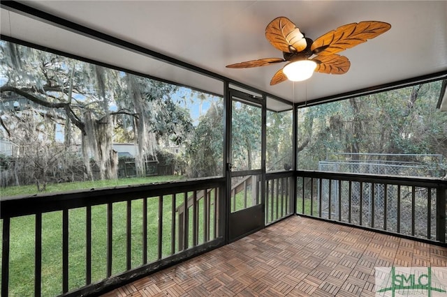 unfurnished sunroom featuring ceiling fan