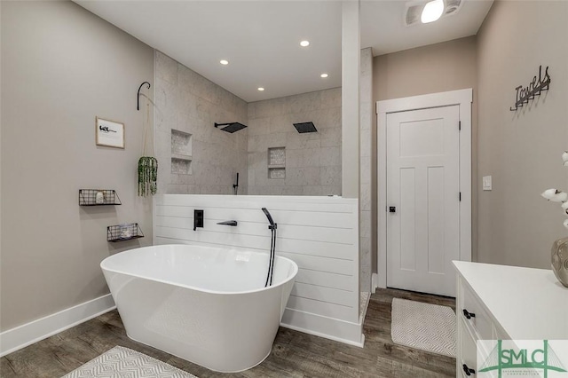 bathroom featuring hardwood / wood-style flooring, plus walk in shower, and vanity