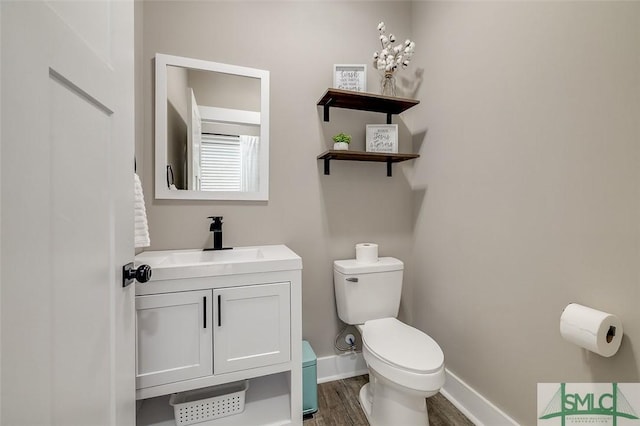 bathroom with vanity, wood-type flooring, and toilet