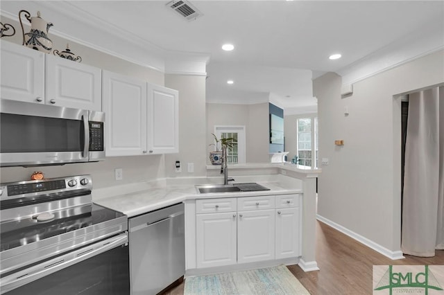 kitchen with stainless steel appliances, white cabinetry, and sink