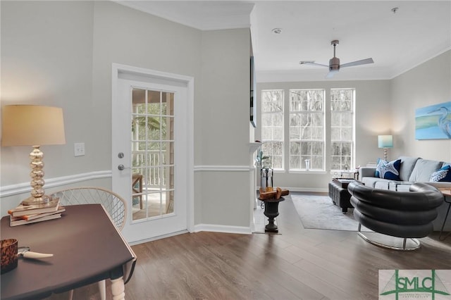 living room featuring wood-type flooring, ornamental molding, and ceiling fan