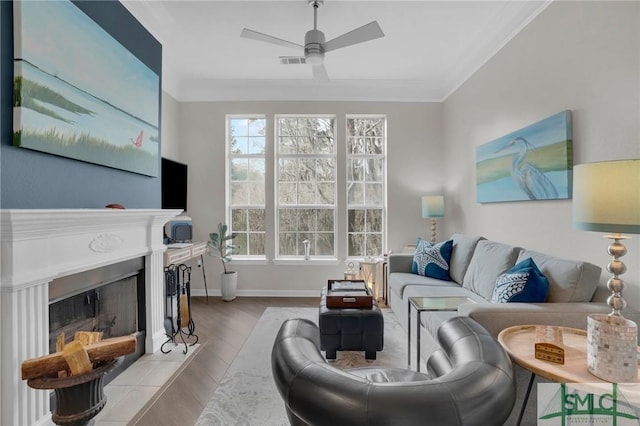 living room with ornamental molding, ceiling fan, and light hardwood / wood-style floors