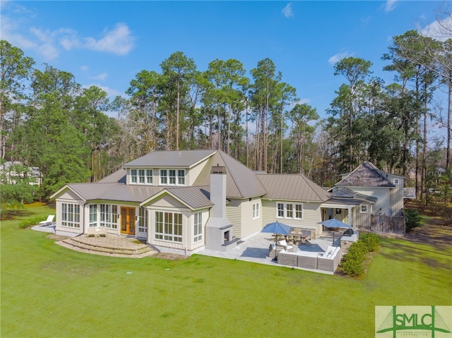 rear view of house with a yard, a sunroom, and a patio