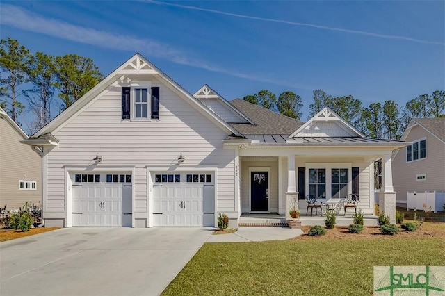 view of front of home featuring a garage, a front yard, and covered porch