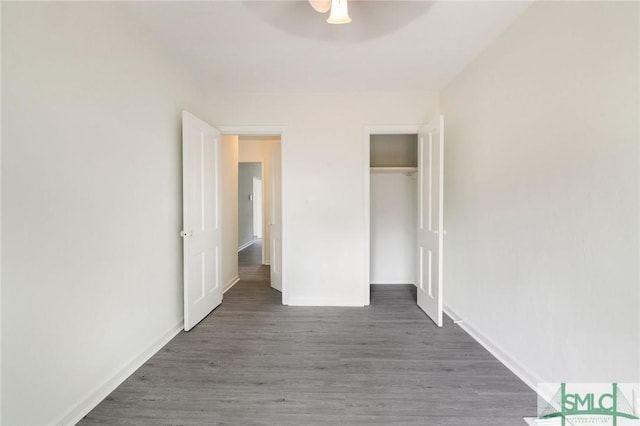 unfurnished bedroom with dark hardwood / wood-style flooring, a closet, and ceiling fan