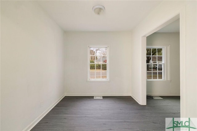 unfurnished room with dark wood-type flooring