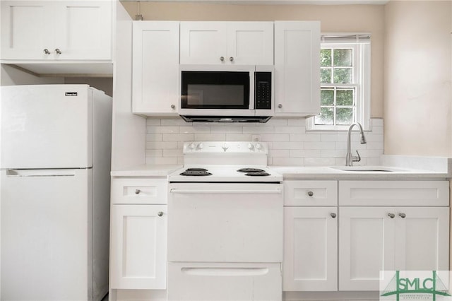 kitchen with sink, white appliances, decorative backsplash, and white cabinets