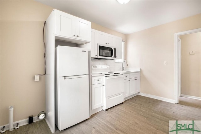 kitchen with sink, white appliances, backsplash, white cabinets, and light wood-type flooring