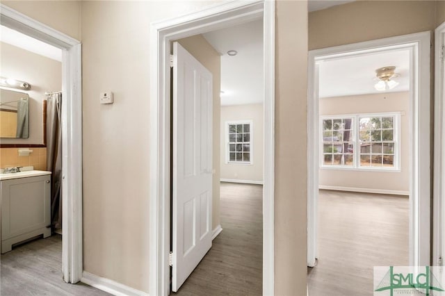 corridor featuring washer / clothes dryer and light hardwood / wood-style floors