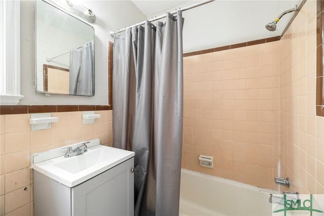 bathroom featuring vanity, tile walls, and shower / bath combo