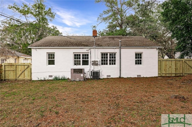 rear view of house with a yard and central air condition unit