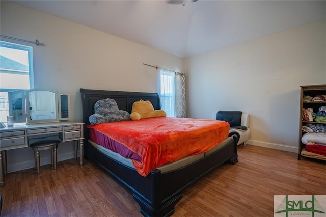 bedroom with hardwood / wood-style flooring and lofted ceiling