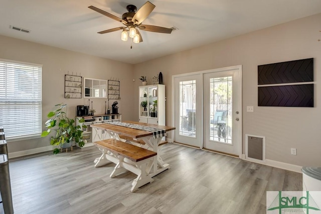 dining space with a wealth of natural light, light hardwood / wood-style floors, and ceiling fan