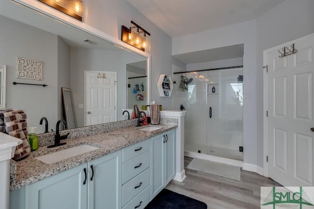 bathroom with vanity, an enclosed shower, and hardwood / wood-style flooring