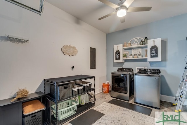 laundry room featuring ceiling fan, electric panel, washer and dryer, and light wood-type flooring