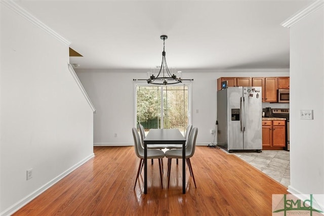 dining room with ornamental molding, light hardwood / wood-style flooring, and a notable chandelier