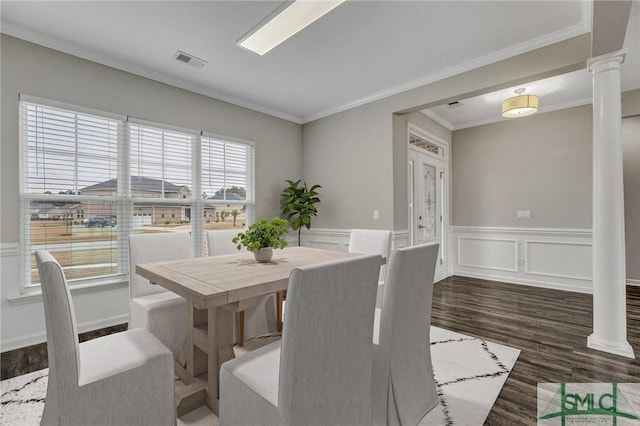 dining room featuring ornate columns, crown molding, and dark hardwood / wood-style floors