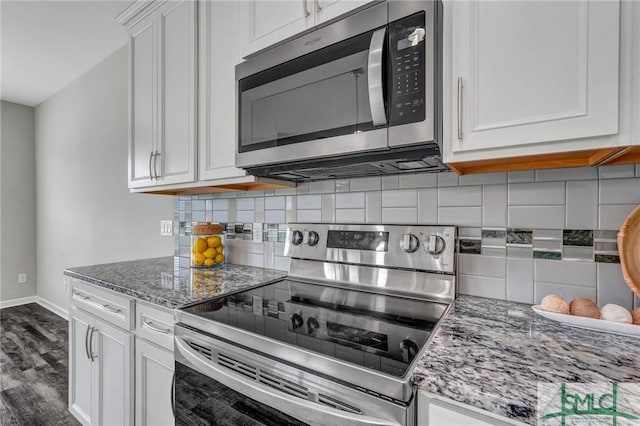 kitchen featuring light stone counters, decorative backsplash, stainless steel appliances, and white cabinets