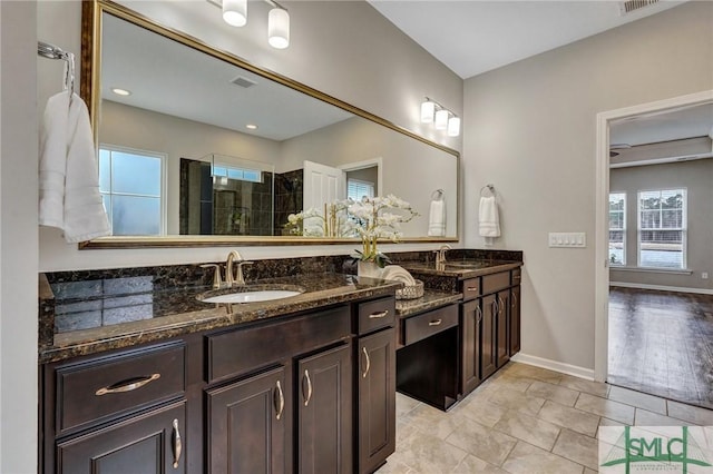 bathroom with tiled shower, vanity, and tile patterned floors