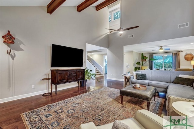 living room featuring beamed ceiling, ceiling fan, plenty of natural light, and dark hardwood / wood-style floors