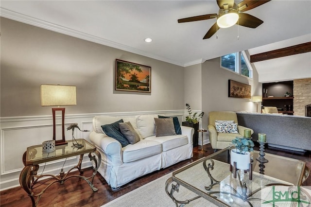 living room with crown molding, vaulted ceiling with beams, hardwood / wood-style floors, and a fireplace