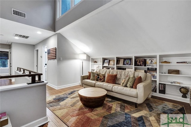 living room featuring hardwood / wood-style flooring and a towering ceiling