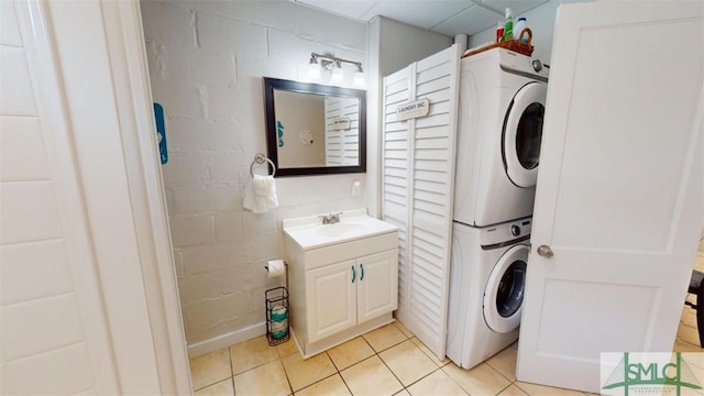 403 13th St, Tybee Island, GA 31328 - laundry area featuring stacked washing maching and dryer and light tile patterned flooring