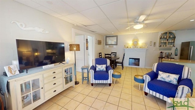 403 13th St, Tybee Island, GA 31328 - living room featuring light tile patterned floors, a drop ceiling, and ceiling fan