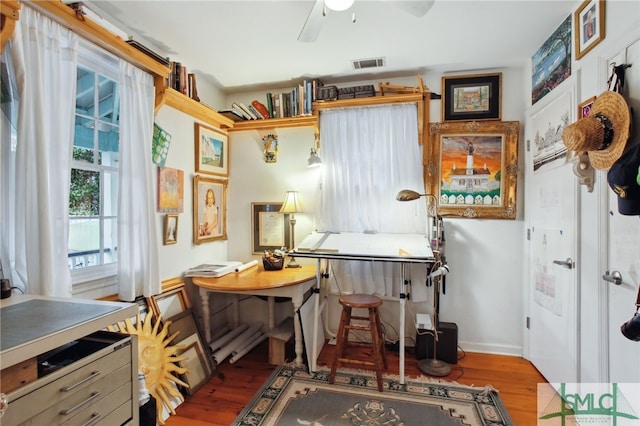 office featuring visible vents, baseboards, ceiling fan, and wood finished floors