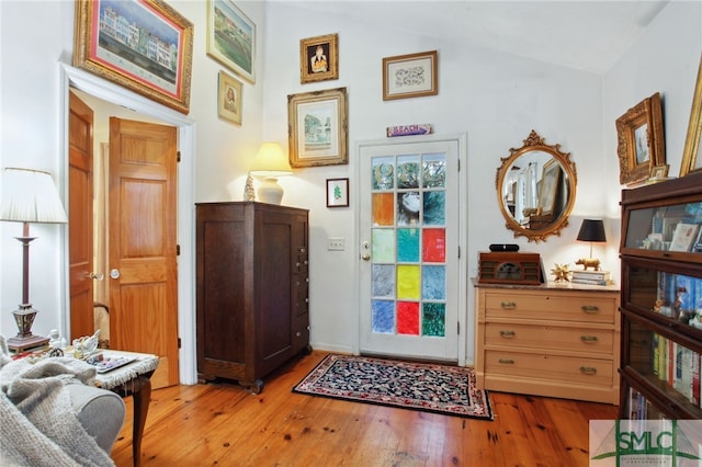 foyer with light wood-type flooring and lofted ceiling