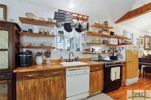 kitchen with open shelves, dishwasher, lofted ceiling, range, and a sink