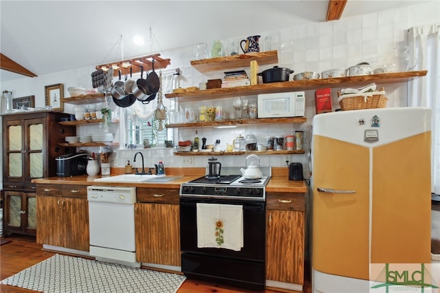 kitchen with tasteful backsplash, white appliances, open shelves, and a sink