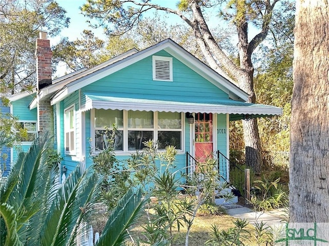 view of front of home featuring fence and a chimney