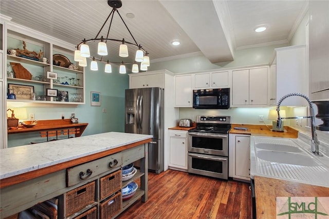 kitchen featuring appliances with stainless steel finishes, decorative light fixtures, white cabinetry, dark hardwood / wood-style flooring, and ornamental molding