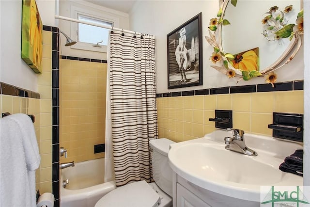 full bathroom with shower / bath combo with shower curtain, toilet, sink, and tile walls