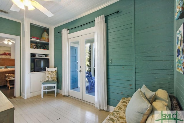 doorway to outside featuring french doors, crown molding, light wood-type flooring, built in features, and ceiling fan