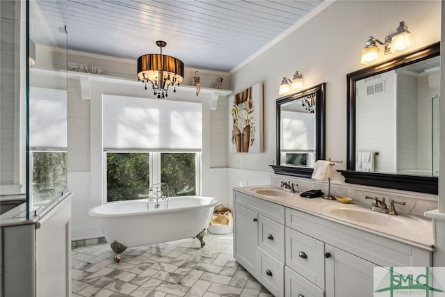 bathroom featuring vanity, crown molding, and a bathing tub