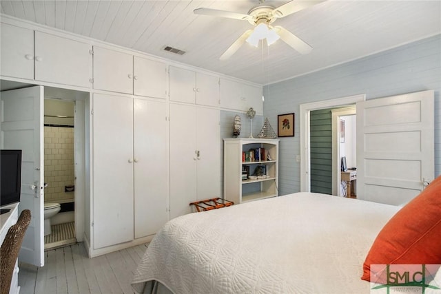 bedroom with ornamental molding, ensuite bathroom, ceiling fan, and light wood-type flooring