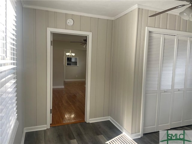 hall featuring crown molding, dark hardwood / wood-style floors, and a notable chandelier